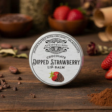 Load image into Gallery viewer, Lip balm container labeled 'Chocolate Dipped Strawberry' on a wooden surface with strawberries and chocolate pieces.