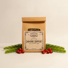 Load image into Gallery viewer, A kraft paper pouch of Fortifying Immune Support Daily Boosting Brew standing on a parchment background with rosehips and pine needles.