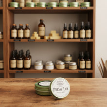 Load image into Gallery viewer, Healing Leaf Apothecary Fresh Ink Tattoo Balm displayed with handcrafted herbal salves in apothecary setting