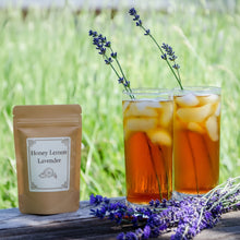 Load image into Gallery viewer, Two glasses of iced tea with lemon balm and lavender, with fresh lavender sprigs for garnish, set against a grassy background.
