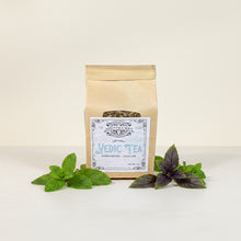 Load image into Gallery viewer, A kraft paper stand-up pouch of Organic Vedic Tea with a white label, displayed on a parchment background.
